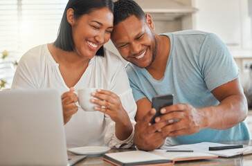 Looks like our application was approved. Shot of a man showing his wife something on his cellphone while sitting at home.