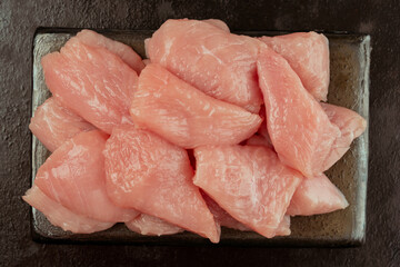 Chicken fillet.Fresh pieces of turkey meat.Raw chicken.Raw pieces of turkey meat on a ceramic board on a black background.Close-up.Ogranic food and healthy eating.