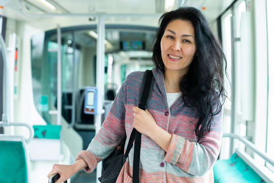 Portrait of young adult woman inside modern city tram