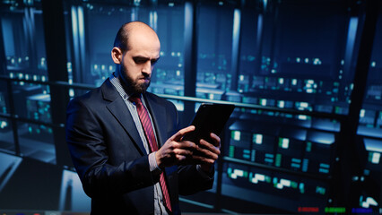 IT administrator running security diagnostics on tablet, inspecting networking service with computer processor big data. Young support specialist checking server rack system quality in data center.