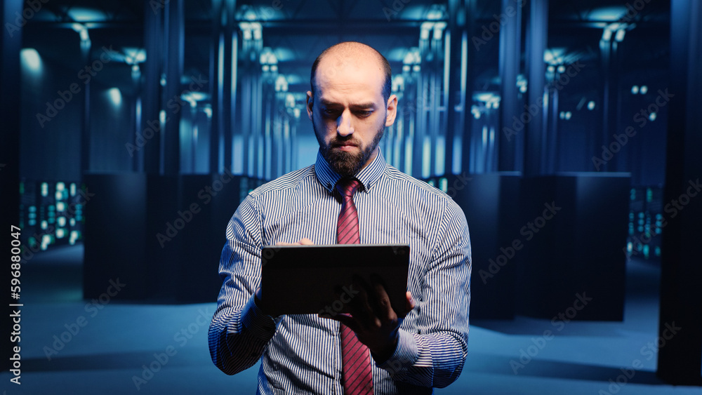 Poster male infrastructure specialist using tablet for hardware digitalization, inspecting cloud computing 