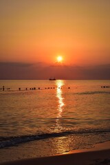 Beautiful morning orange landscape by the Polish sea. Boat in the Baltic Sea with the rising sun in the background. Photo taken in Jastarnia, Poland. - 596883085