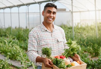 You can create many delicious dishes with these. Portrait of a young man holding a crate of fresh produce while working on a farm.
