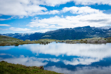 Fototapeta na wymiar Amazing reflection over a lake in the mountains of Trolltunga hike, Norway