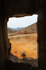 Paisaje desértico visto desde el interior de una ventana en ruinas