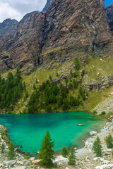 Fototapeta na wymiar The crystal clear water of the Blue Lake of Ayes, Italian Alps