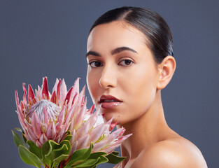 Turn to nature for all things wonderful. Studio shot of a beautiful young woman posing with proteas...