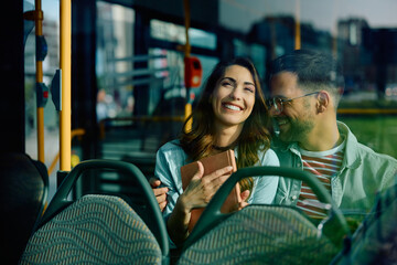 Young happy couple in love riding in bus.