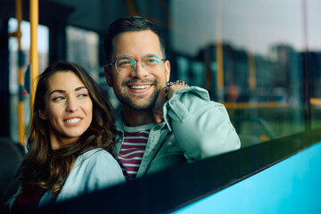 Happy couple looks through the window while riding in bus.