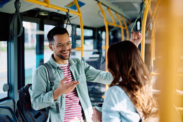 Young couple talk and laugh while commuting by bus.