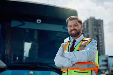 Happy bus driver with arms crossed looking at camera.