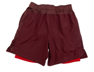Red two-layer running shorts isolated on white background. Sports shorts with leggings sewn inside for running, fitness, yoga and other workouts. Back view.
