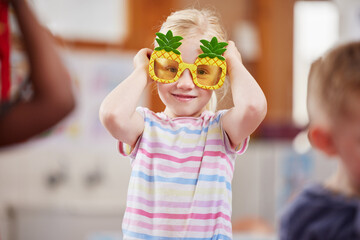 Pineapples are my favourite. Shot of a little girl wearing funky glasses in class.