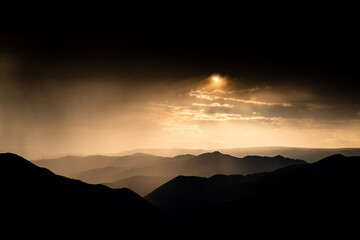 banner of mountain peaks in beautiful stormy sunset light
