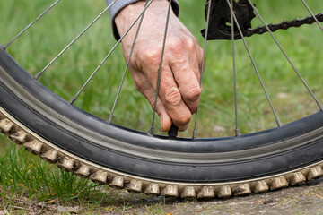 Bicycle wheel close-up.A man removes the cap on the wheel.Inflating a bicycle wheel.