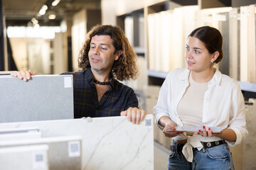 Happy husband and wife choose and buy ceramic flooring together