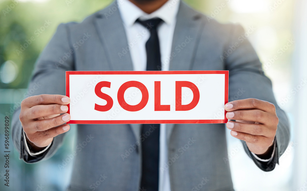 Poster To the highest bidder you go. Cropped shot of an unrecognizable businessman holding up a sold sign while standing in the office.