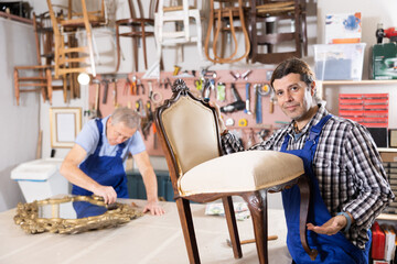 Male furniture maker working on vintage chair in workshop