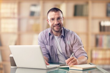 Obraz premium Happy professional young business man on library background