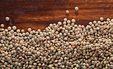 Image of raw lentil background on wooden surface, nutritious food
