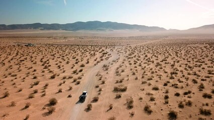 Truck towing trailing on a desert dirt trail