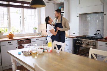 Living the sweet life. Shot of an affectionate couple dancing while baking together at home.