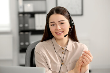 Hotline operator with headset working in office