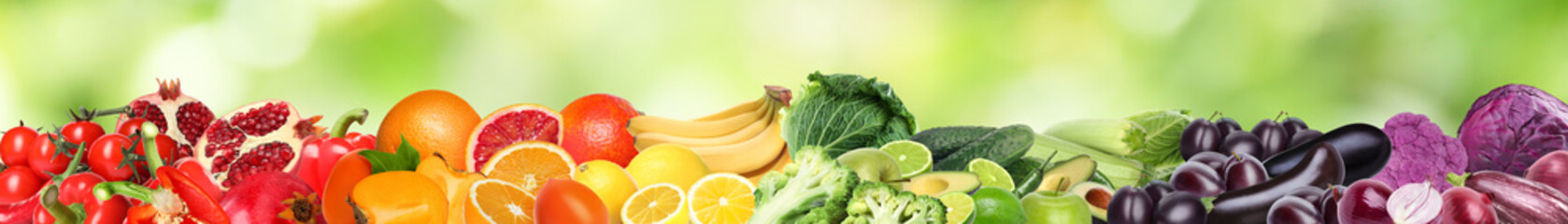 Many different fresh fruits and vegetables against blurred green background. Banner design