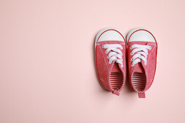 Cute baby shoes on beige background, flat lay. Space for text
