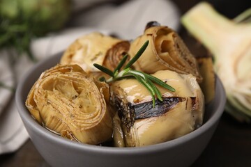 Bowl with delicious artichokes pickled in olive oil on table, closeup