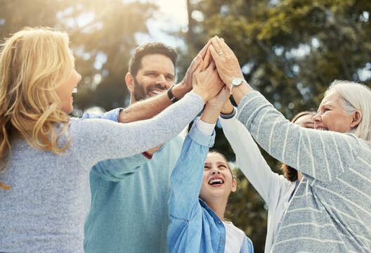Love your family as you love yourself. Shot of a family giving each other a high five in the garden at home. - Powered by Adobe