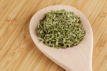 Dried Tarragon Leaves isolated on a wooden cutting board