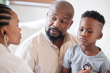 African american female paediatrician examining sick boy with stethoscope during visit with dad. Doctor checking heart and lungs during checkup in hospital. Sick or sad boy receiving medical care