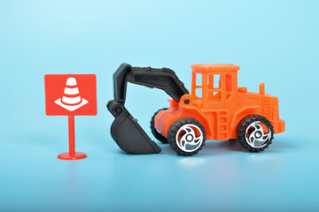 A toy excavator at a construction site, surrounded by safety cones, symbolizing the importance of safety measures and precautions in the construction industry.