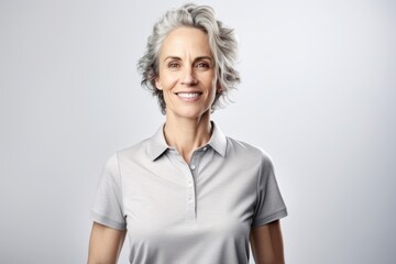 Full-length portrait photography of a grinning woman in her 40s wearing a sporty polo shirt against a white background. Generative AI