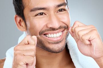 Theres no doubt failing to floss leaves your smile in danger. Shot of a man using dental floss...