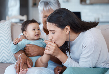 Chubby toe attack. Shot of a mature woman bonding with her granddaughter and daughter on the sofa at home.