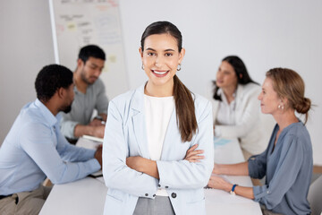 This team fills me with confidence. Cropped portrait of an attractive young businesswoman standing with her arms folded in the boardroom and her colleagues in the background.