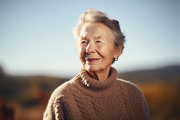 Portrait of a smiling senior woman in the autumn park on a sunny day