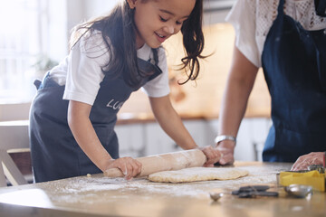 Obraz na płótnie Canvas Baking sure is fun. Shot of an adorable little girl rolling out dough.