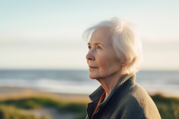 Fototapeta na wymiar Portrait of a senior woman looking away at the beach in autumn