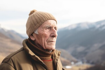 Fototapeta na wymiar Portrait of senior man in winter clothes looking away in the mountains