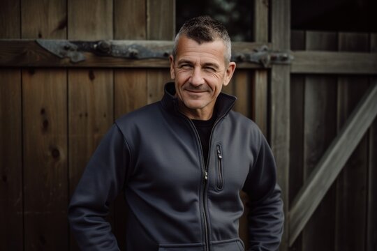 Portrait of a handsome middle-aged man in a black sweatshirt smiling at the camera.