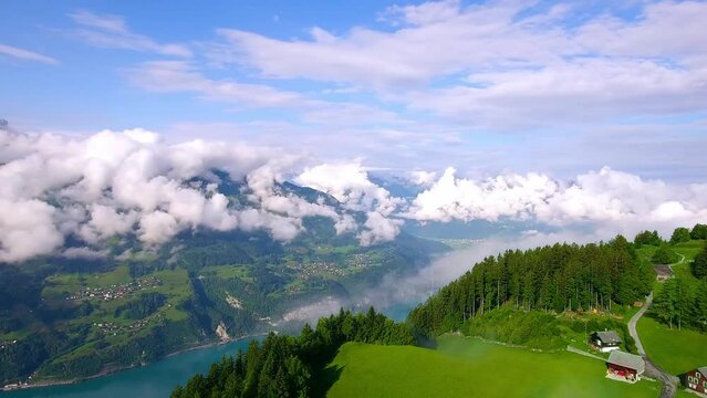 Aerial view of cloud-shrouded mountains, green river, forest and grassland, beautiful natural landscape