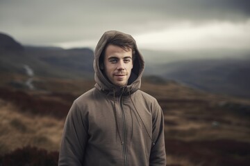 Handsome young man standing on the top of a mountain in Scotland