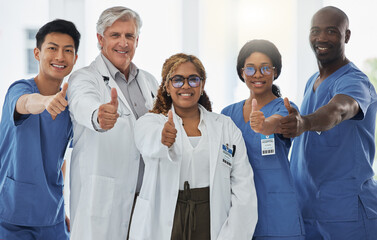 Fototapeta na wymiar We care, collaborate and communicate to address all aspects. Portrait of a group of medical practitioners showing thumbs up together in a hospital.