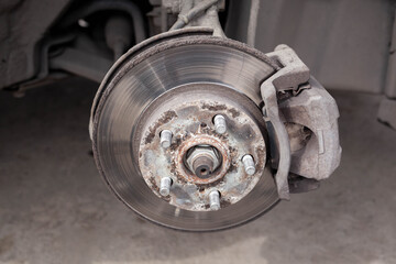 Disc brake of the vehicle for repair, in process of new tire replacement. Car brake repairing in...