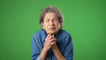 Portrait of tired, sleepy elderly senior old woman hold hands folded in prayer begging about...