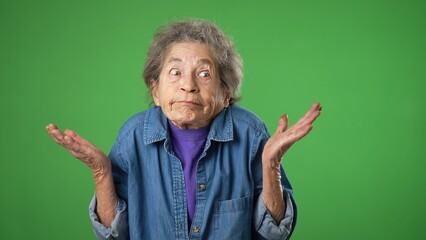 Portrait of happy elderly senior old woman with wrinkled skin and grey hair shrugging shoulders and...