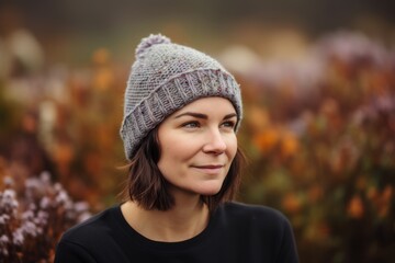 Portrait of a beautiful girl in a knitted hat on a background of autumn leaves